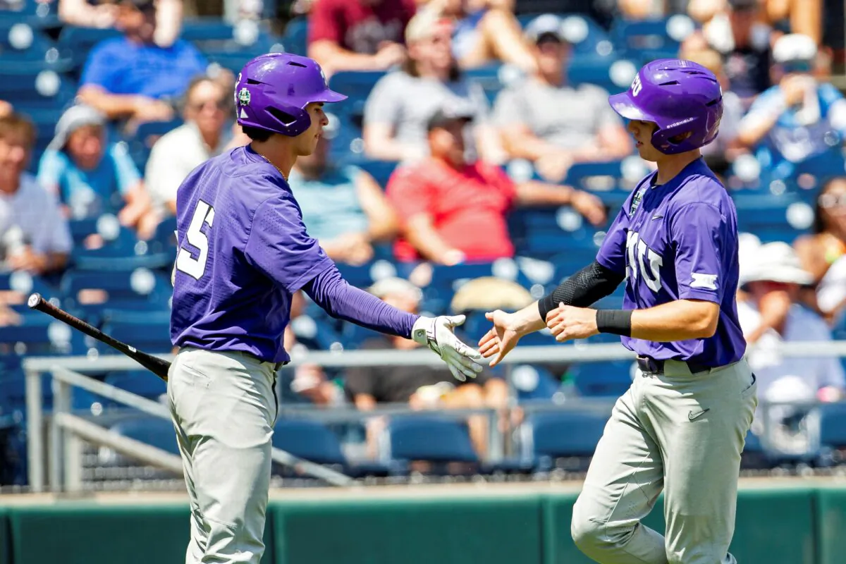 TCU's Brayden Taylor (55) gets five from Anthony Silva for scoring a run in the fifth inning of a baseball game against Oral Roberts at the NCAA College World Series in Omaha, Neb., on June 20, 2023. (John Peterson/AP Photo)