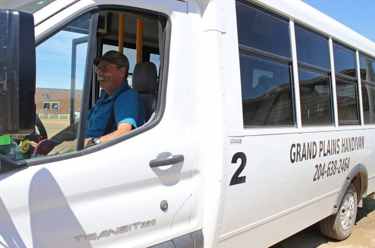 Doug Westhouse sits behind the wheel of a 12-passenger bus in Grandview, Man. on June 20, 2023. (The Canadian Press/Kelly Geraldine Malone)