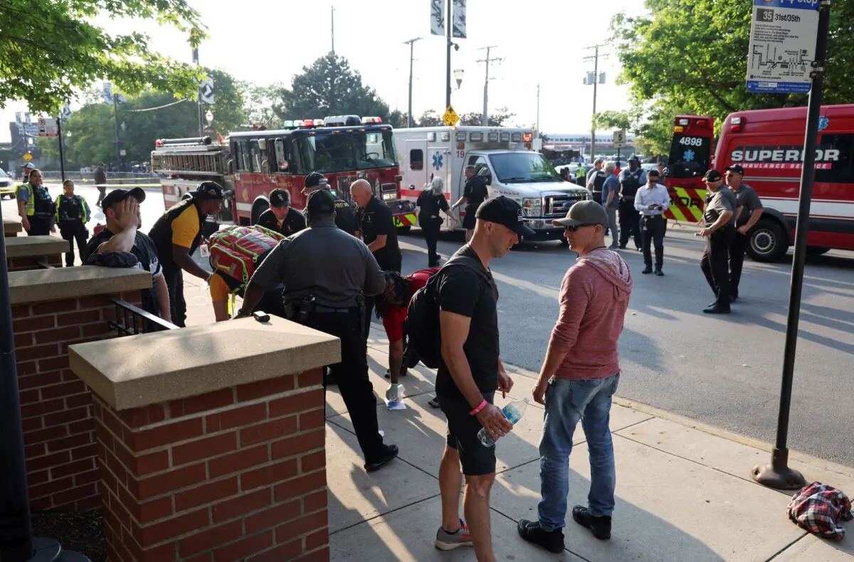 Baseball fans and first responders stand outside Guaranteed Rate Field on West 35th Street after pedestrians were struck by a vehicle before a game in Chicago on June 20, 2023. (John J. Kim/Chicago Tribune via AP)