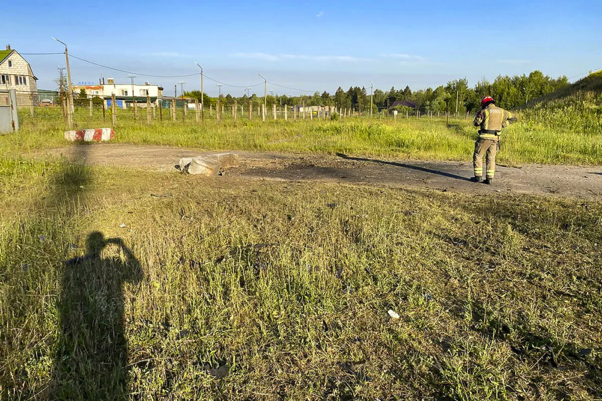An emergency services employee walks near the site where a drone crashed, near Kalininets, outside Moscow, Russia on June 21, 2023. (Moscow Region Governor Andrei Vorobyev telegram channel via AP)