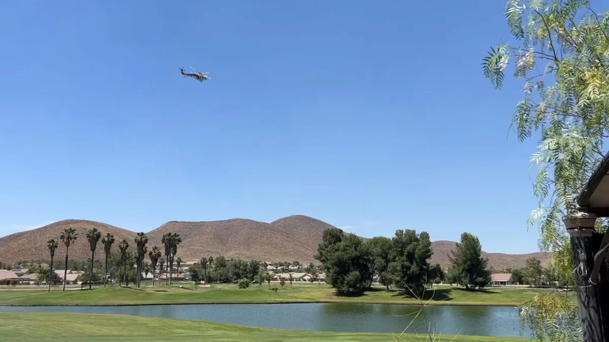 A CAL FIRE helicopter flying towards the Garbani FIre after picking up water from the Palms Golf Course at the Menifee Lakes County Club, June 20, 2023 in Menifee, Calif. (Brad Jones/The Epoch Times)