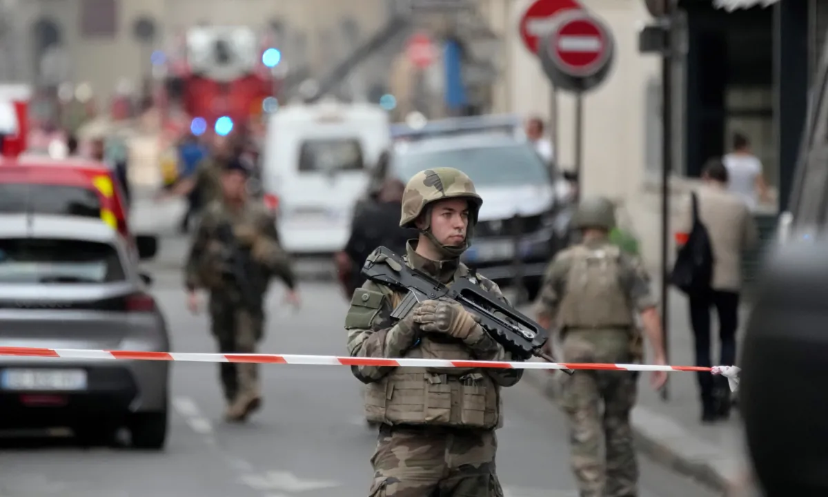A soldier secures the are as firemen fight a blaze in Paris on June 21, 2023. (Christophe Ena/AP Photo)