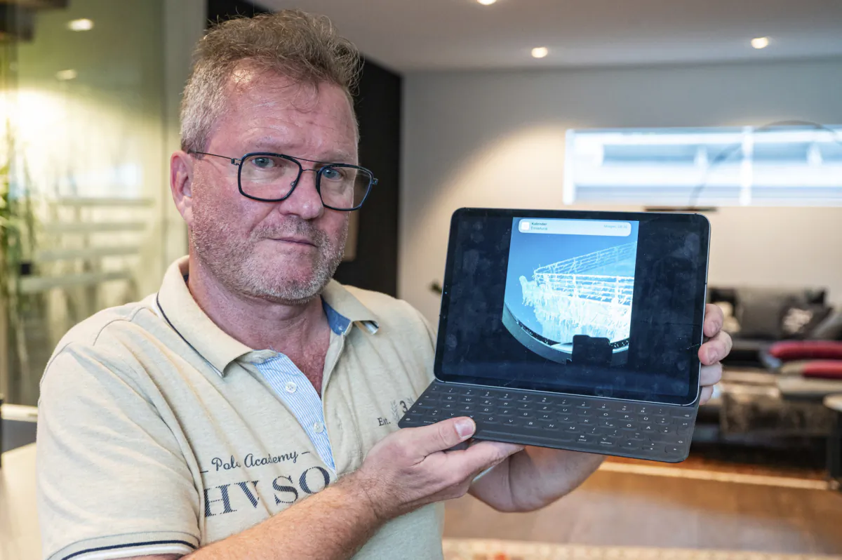 Arthur Loibl, one of the submersible company Oceangate's first customers, holds up a photo of the Titanic, in Straubing, Germany, on June 21, 2023. (Armin Weigel/dpa via AP)