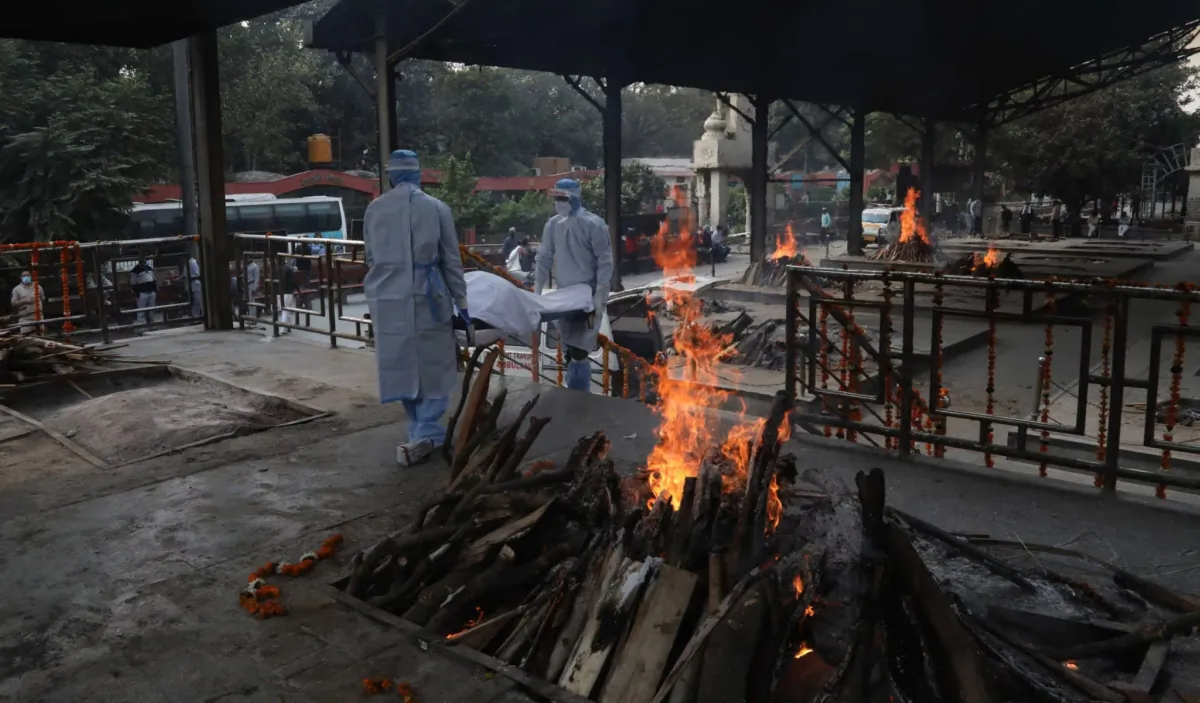 The body of a COVID-19 victim is carried to a funeral pyre for cremation at a Nigambodh Ghat crematorium in New Delhi, India, on April 14, 2021. (Exposure Visuals/Shutterstock)