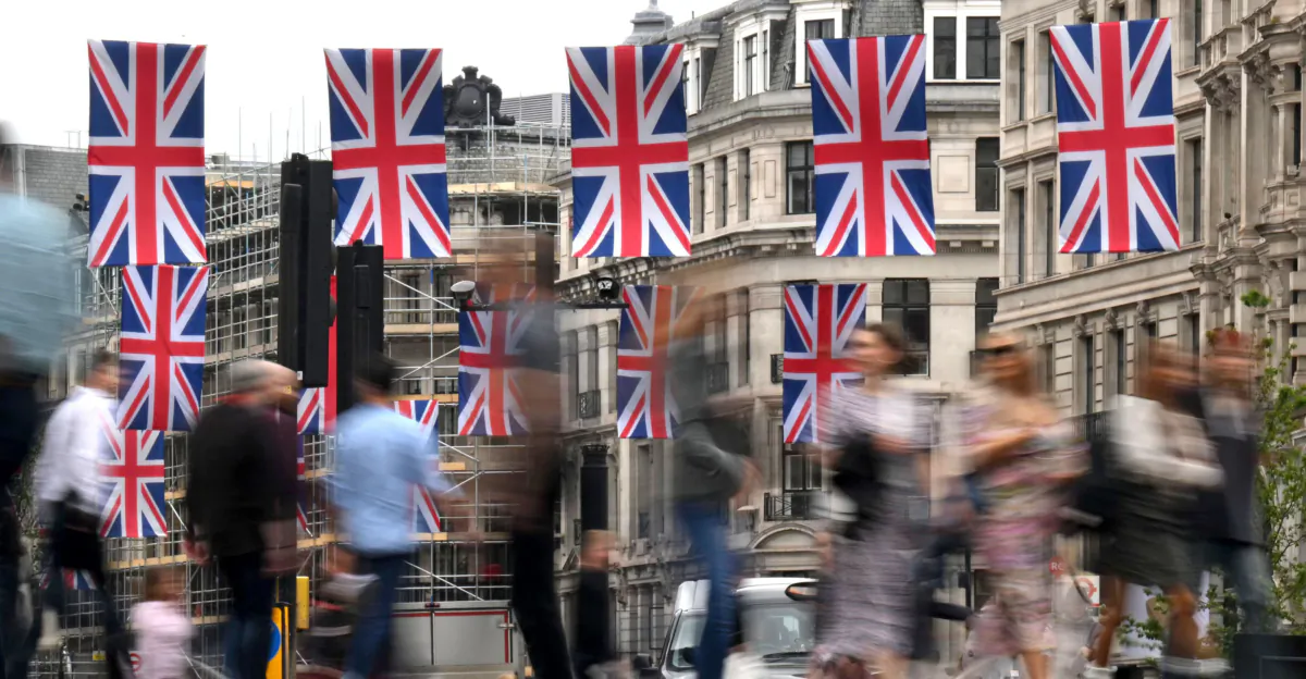 Pedestrians walk past Union Jack flags at Oxford Circus in London on May 25, 2023. (Daniel Leal/ AFP/Getty Images)