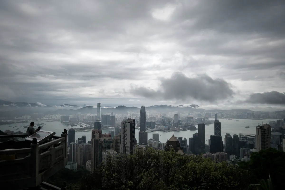 A man (L) looks at the city's skyline as a storm approaches in Hong Kong on April 2, 2014. (PHILIPPE LOPEZ/AFP/Getty Images)