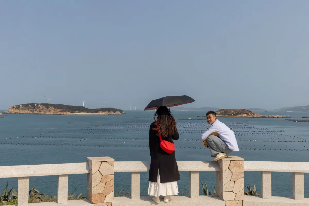 People stand on a viewing platform overlooking the Taiwan Strait on Pingtan Island, Fujian Province, China, on April 10, 2023. (Thomas Peter/Reuters)