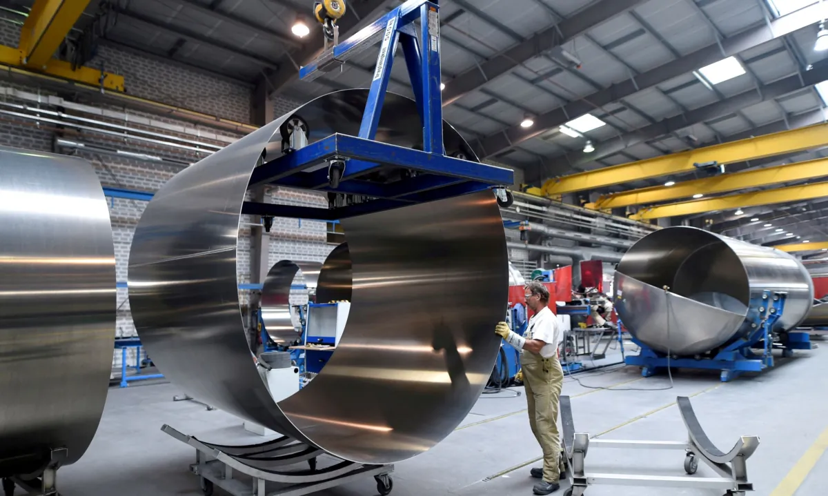 A worker at German manufacturer of silos and liquid tankers, Feldbinder Special Vehicles, moves rolls of aluminium at the company's plant in Winsen, Germany, on July 10, 2018. (Fabian Bimmer/Reuters)