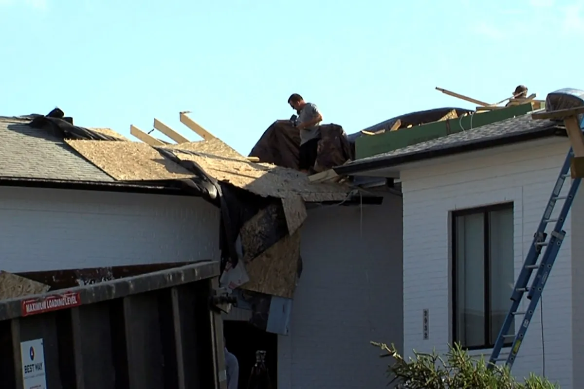 A man surveys a roof of a home severely damaged after a tornado touched down in Johnson County, Ind., on June 25, 2023. (WRTV via AP)