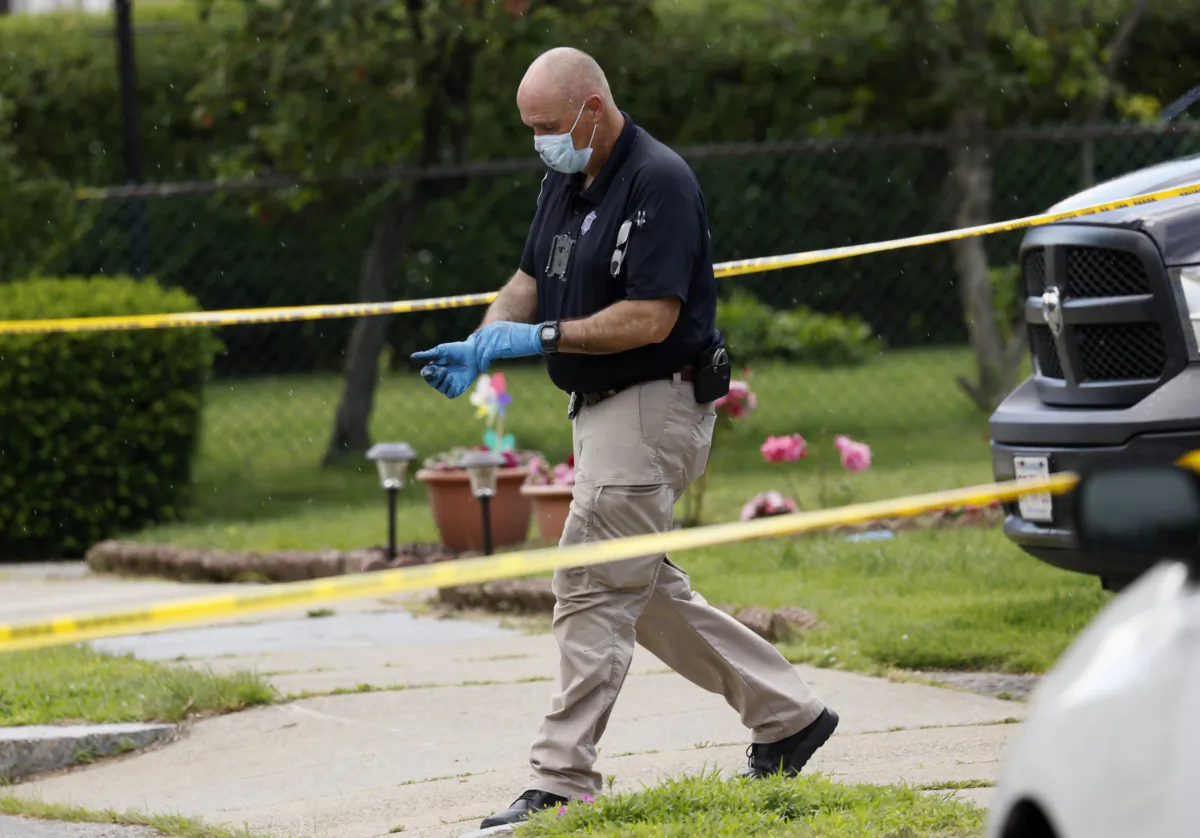 An investigator walks out of a home along Broadway Street in Newton, Mass., on June 25, 2023. (Jessica Rinaldi/The Boston Globe via AP)