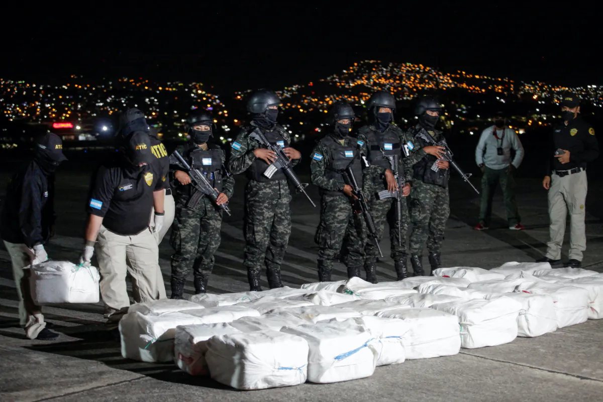 Officers of Honduras' Technical Agency for Criminal Investigation carry a package containing cocaine seized during a police operation, at a presentation to the media, in Tegucigalpa, Honduras, on Dec. 11, 2022. (Fredy Rodriguez/Reuters)