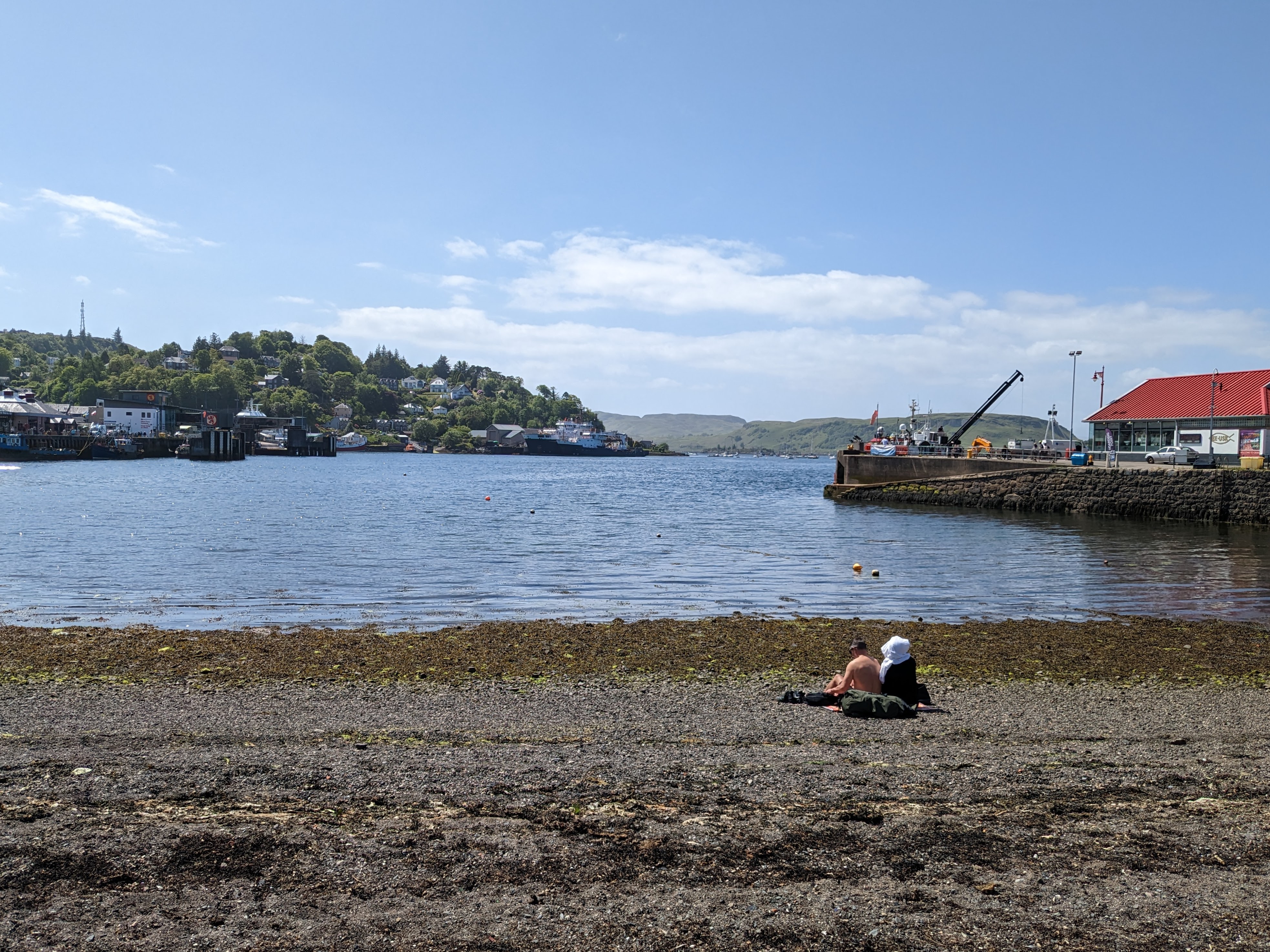 A view of Oban Bay from a rocky beach in Oban, Scotland.