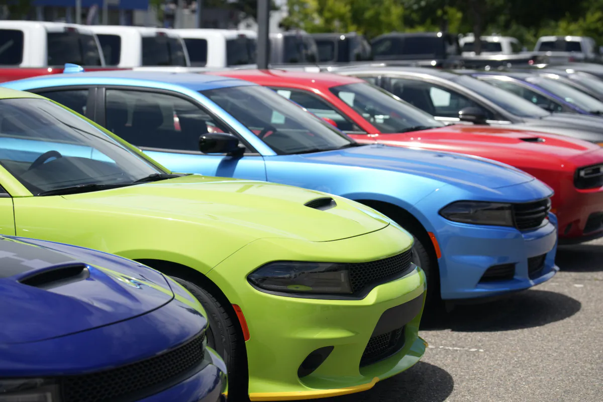 Unsold 2023 Charger sedans and Challenger hardtops sit in a long row at a Dodge dealership in Littleton, Colo. on June 18, 2023. (David Zalubowski/AP Photo)