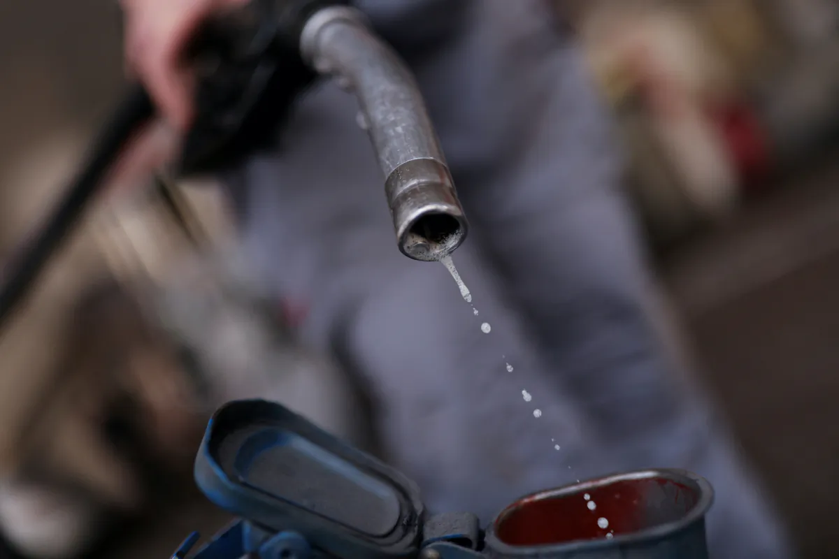A worker pumps petrol for a customer at a petrol station in Barcelona, Spain, February 4, 2022. (Nacho Doce/Reuters)