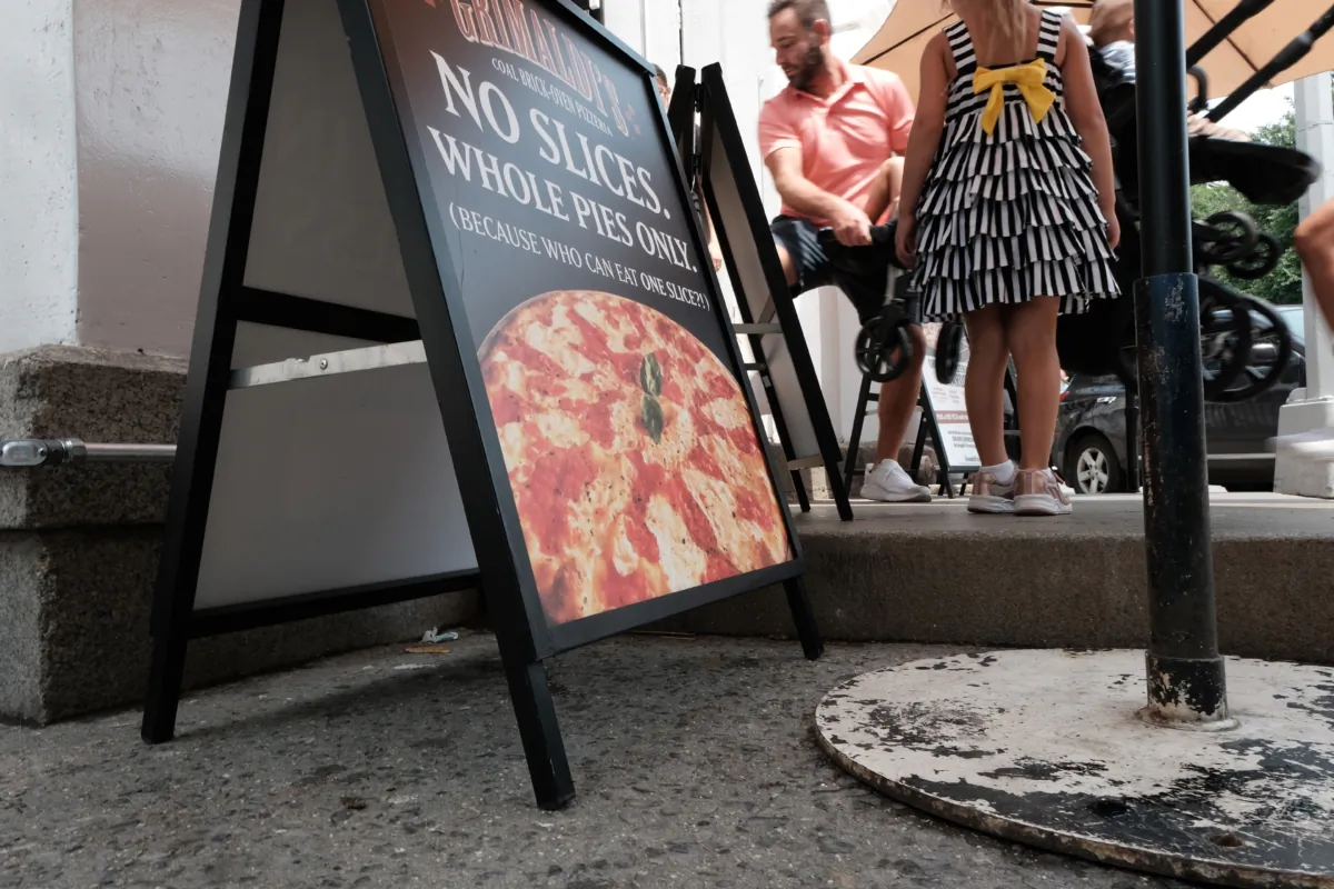 People walk outside of the Brooklyn pizzeria Grimaldi's which makes coal oven pizzas, in New York City on June 26, 2023. (Spencer Platt/Getty Images)