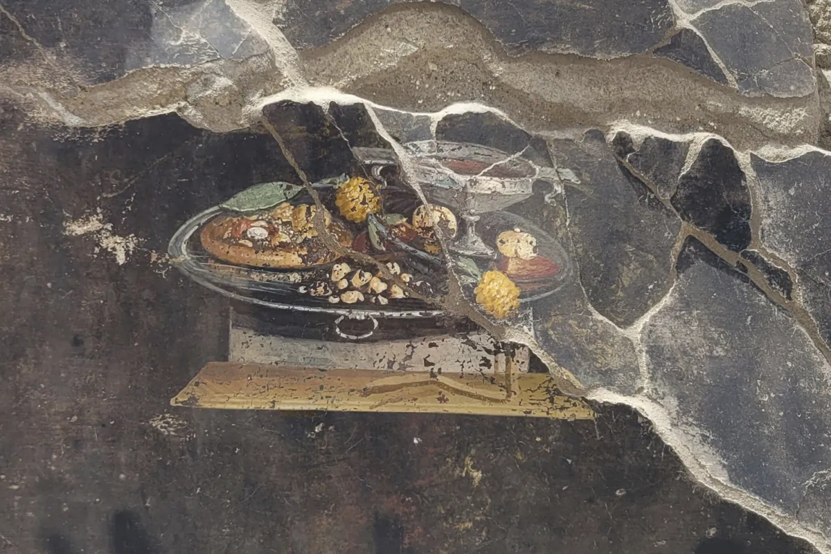 The wall of an ancient Pompeian house with a fresco depicting a table with food, in a photo provided on June 27, 2023. (Pompeii Archaeological Park via AP)
