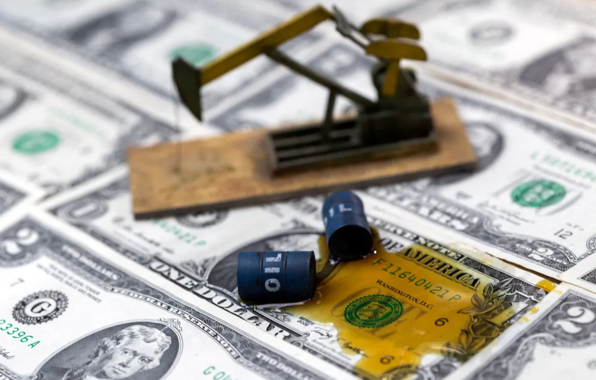 Oil, miniatures of oil barrels, oil pump jack and U.S. dollar banknote are seen in this illustration taken on June 6, 2023. (Dado Ruvic/Reuters)