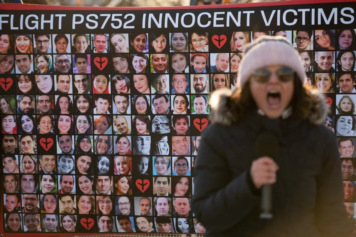 A protestor chants in front of a poster with the faces of the victims of Ukraine International Airlines Flight PS752 in Ottawa, on Jan. 8, 2023. (The Canadian Press/Spencer Colby)
