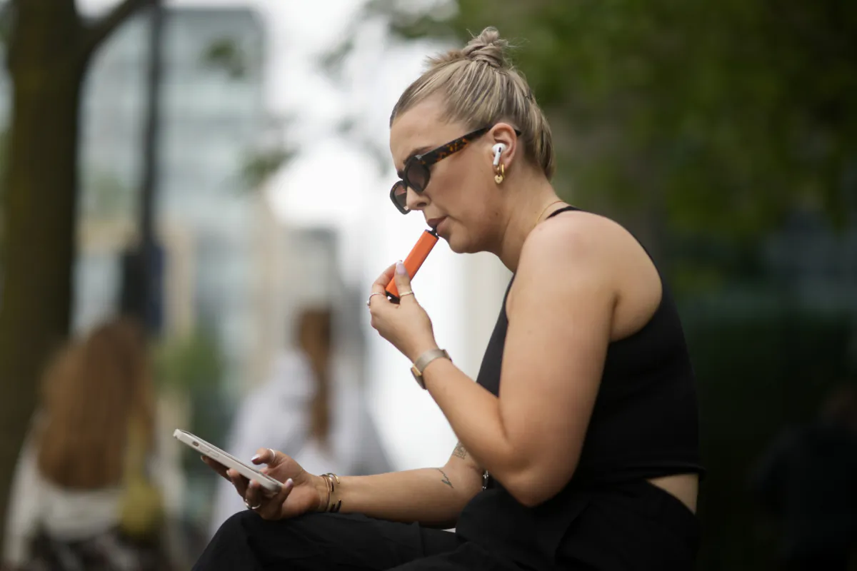 A woman smokes a vaping device in Manchester, England, on May 30, 2023. (Christopher Furlong/Getty Images)