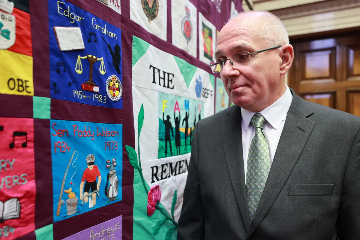 Paul Wilson, the son of Paddy Wilson, stands beside a memorial quilt created by the South East Fermanagh Foundation (SEFF) during an event,  marking the 50th anniversary of the murder of his father SDLP senator Paddy Wilson, in Stormont on June 26, 2023. (Liam McBurney/PA Wire)