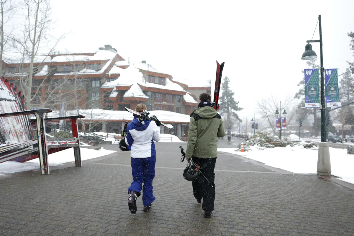 People carry skis as they walk towards a resort in South Lake Tahoe, Calif., on March 21, 2023. (Justin Sullivan/Getty Images)