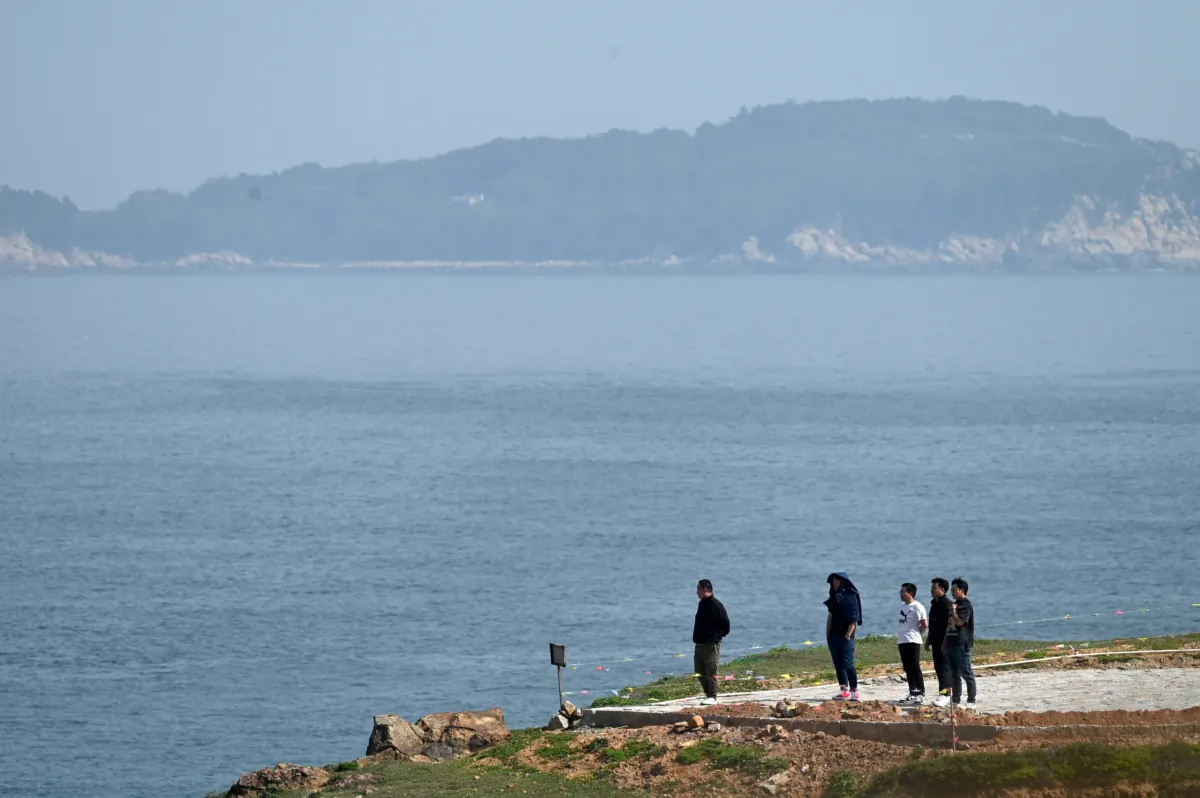 A group of men look out to the Taiwan Strait from Pingtan island, the closest point in China to Taiwan, in southeast China's Fujian province on April 16, 2023. (Greg Baker/AFP via Getty Images)
