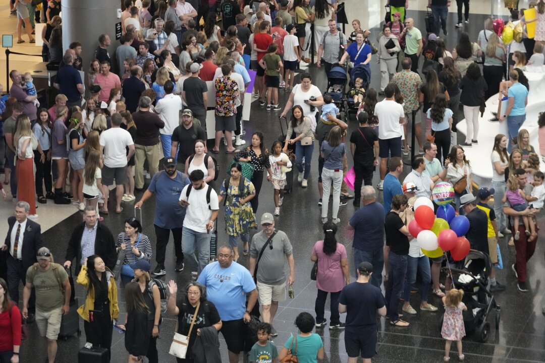 Travelers walk through crowds at an airport as seen in a file photo. (Rick Bowmer/AP Photo)