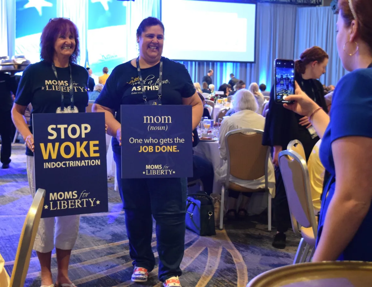 Two attendees at the Moms for Liberty national summit in Philadelphia pose for photos on July 2, 2023. (Beth Brelje/The Epoch Times)