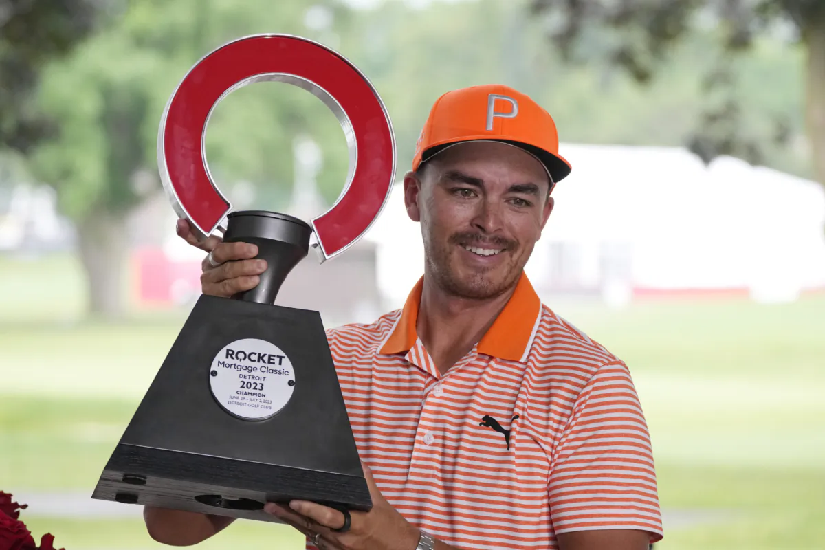 Rickie Fowler holds the winner's trophy after winning on the first play-off hole on the 18th green during the final round of the Rocket Mortgage Classic golf tournament at Detroit Country Club in Detroit on July 2, 2023. (Carlos Osorio/AP Photo)