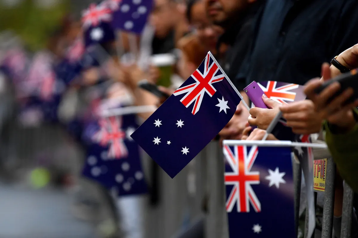 Members of the public wave the Australian flag as they watch the ANZAC Day March in Sydney, Australia, on April 25, 2023. (AAP Image/Bianca De Marchi) 