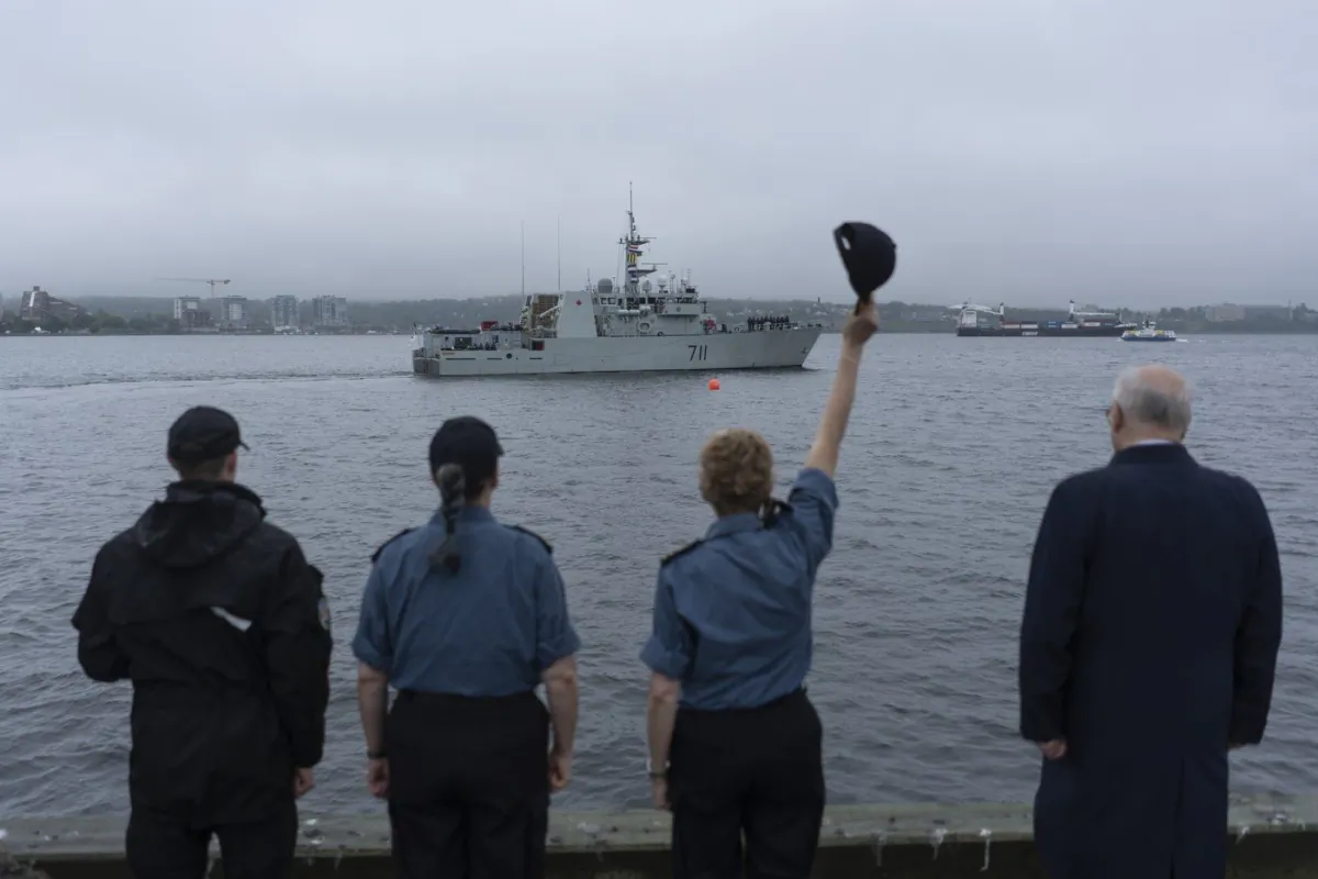 HMCS Summerside sails from its homeport in Halifax as Rear-Admiral Josée Kurtz raises her cap during the departure ceremony for HMCS Summerside and HMCS Shawinigan, in Halifax, July 3, 2023. (The Canadian Press/Darren Calabrese)
