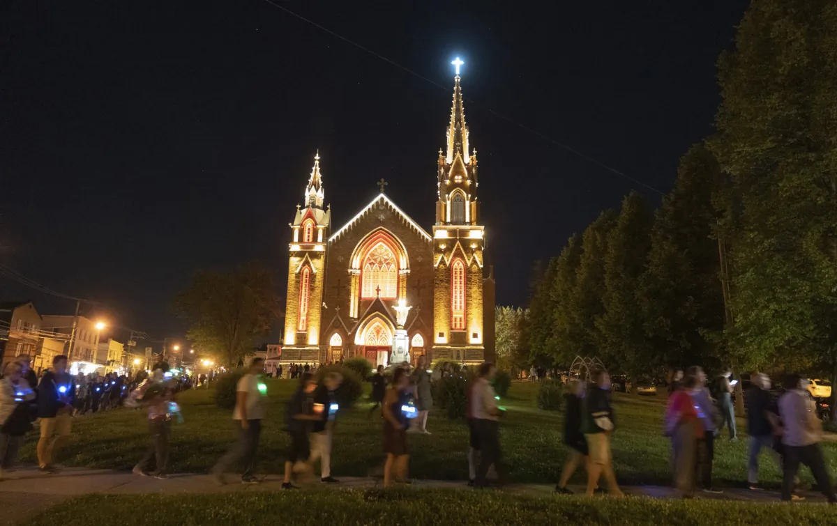 People take part in a silent march to pay tribute to the 47 victims of an oil-filled train derailment that occurred ten years ago, on July 6, 2023 in Lac-Mégantic, Que. (The Canadian Press/Christinne Muschi)