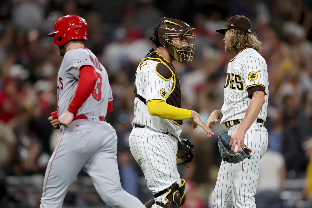 Taylor Ward (3) of the Los Angeles Angels leaves the field as Gary Sanchez (99) and Josh Hader (71) of the San Diego Padres celebrate after defeating the Los Angeles Angels in a game at PETCO Park in San Diego on July 5, 2023. (Sean M. Haffey/Getty Images)