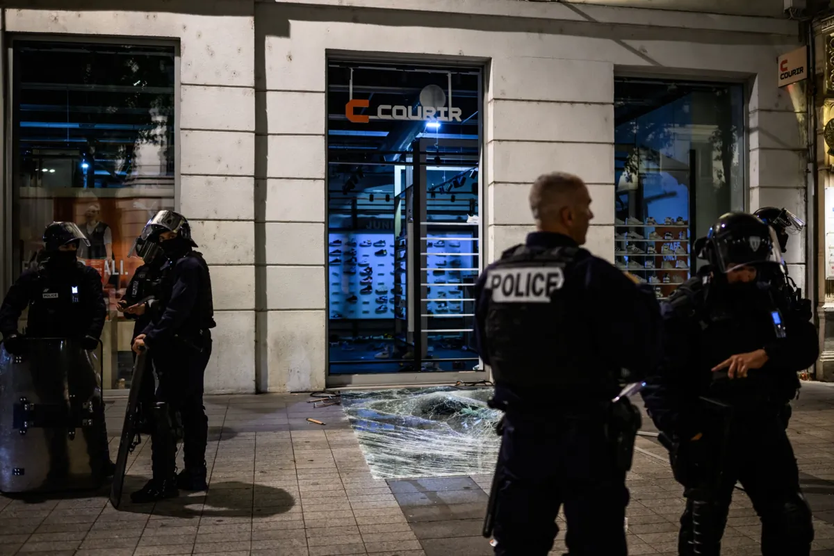 Police officers stand in front of a looted shop during clashes with police in Lyon, south-eastern France, on June 30, 2023, three days after a 17-year-old boy was shot in the chest by police at point-blank range in Nanterre, a western suburb of Paris. (Jeff Pachoud /AFP via Getty Images)