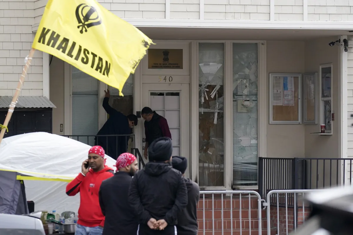 People inspect damage to the entrance to the Consulate General of India as protesters stand outside barricades in San Francisco, on March 20, 2023. (Jeff Chiu/AP Photo)