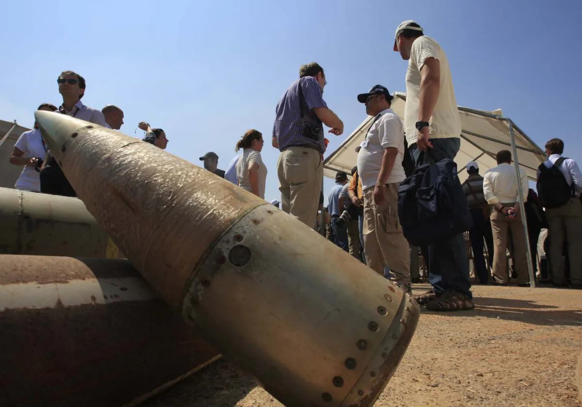 Activists and international delegations stand next to cluster bomb units during a visit to a Lebanese military base at the opening of the Second Meeting of States Parties to the Convention on Cluster Munitions in the southern town of Nabatiyeh, Lebanon, on Sept. 12, 2011. (Mohammed Zaatari/AP Photo)