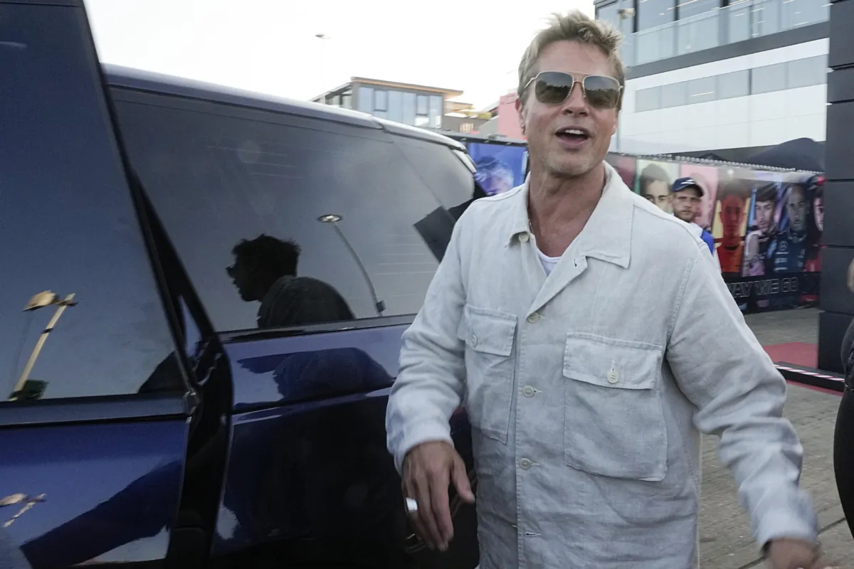 Actor Brad Pitt cheers fans leaving the paddock after the second free practice at the British Formula One Grand Prix at the Silverstone racetrack, Silverstone, England, on July 7, 2023. (Luca Bruno/AP Photo)
