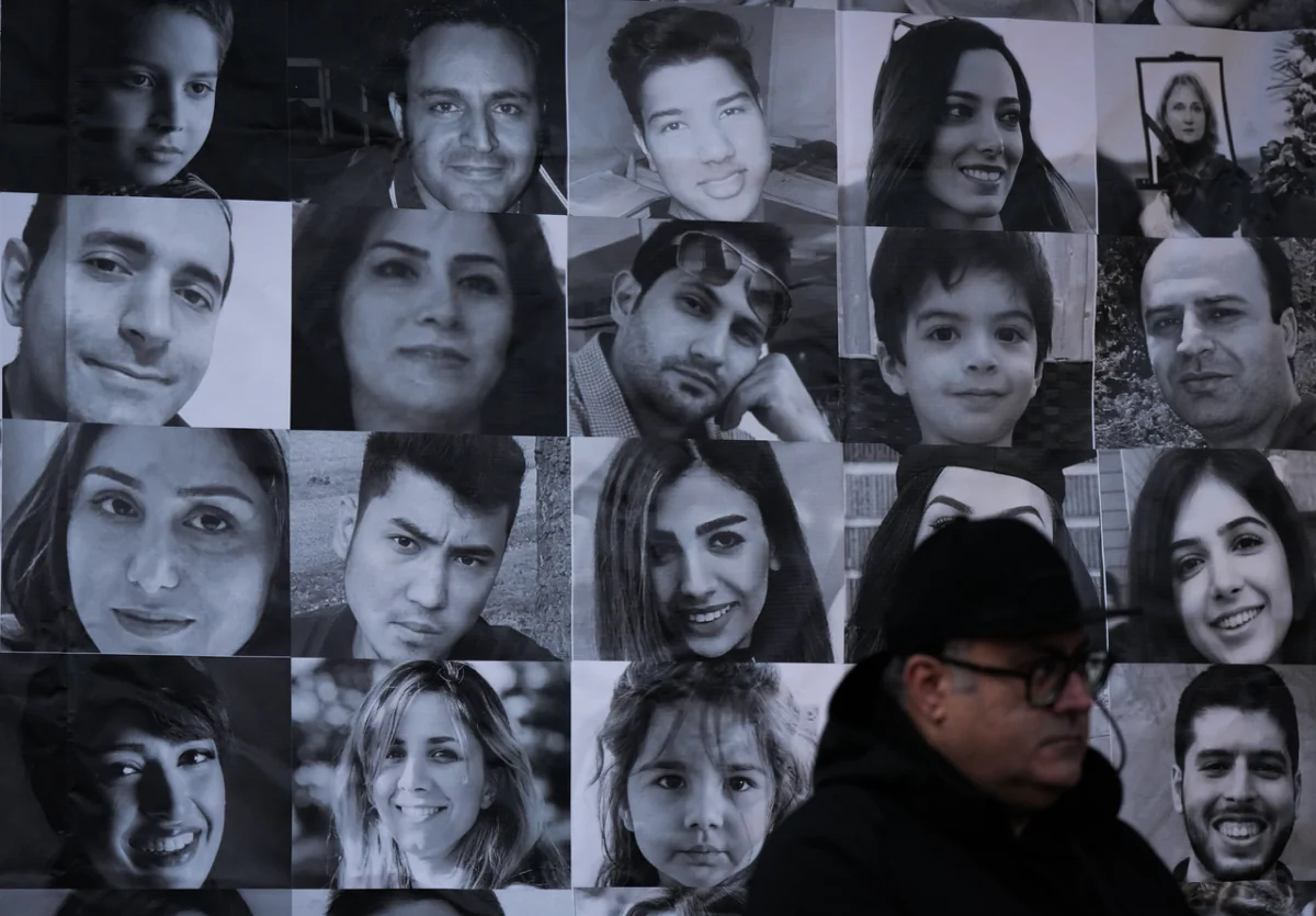 Photographs of victims of Flight PS752 are seen as thousands of people attend a rally to mark the National Day of Remembrance for Victims of Air Disasters, on the three-year anniversary since the Iranian military shot down the flight, in North Vancouver on Jan. 8, 2023. (Darryl Dyck/The Canadian Press)