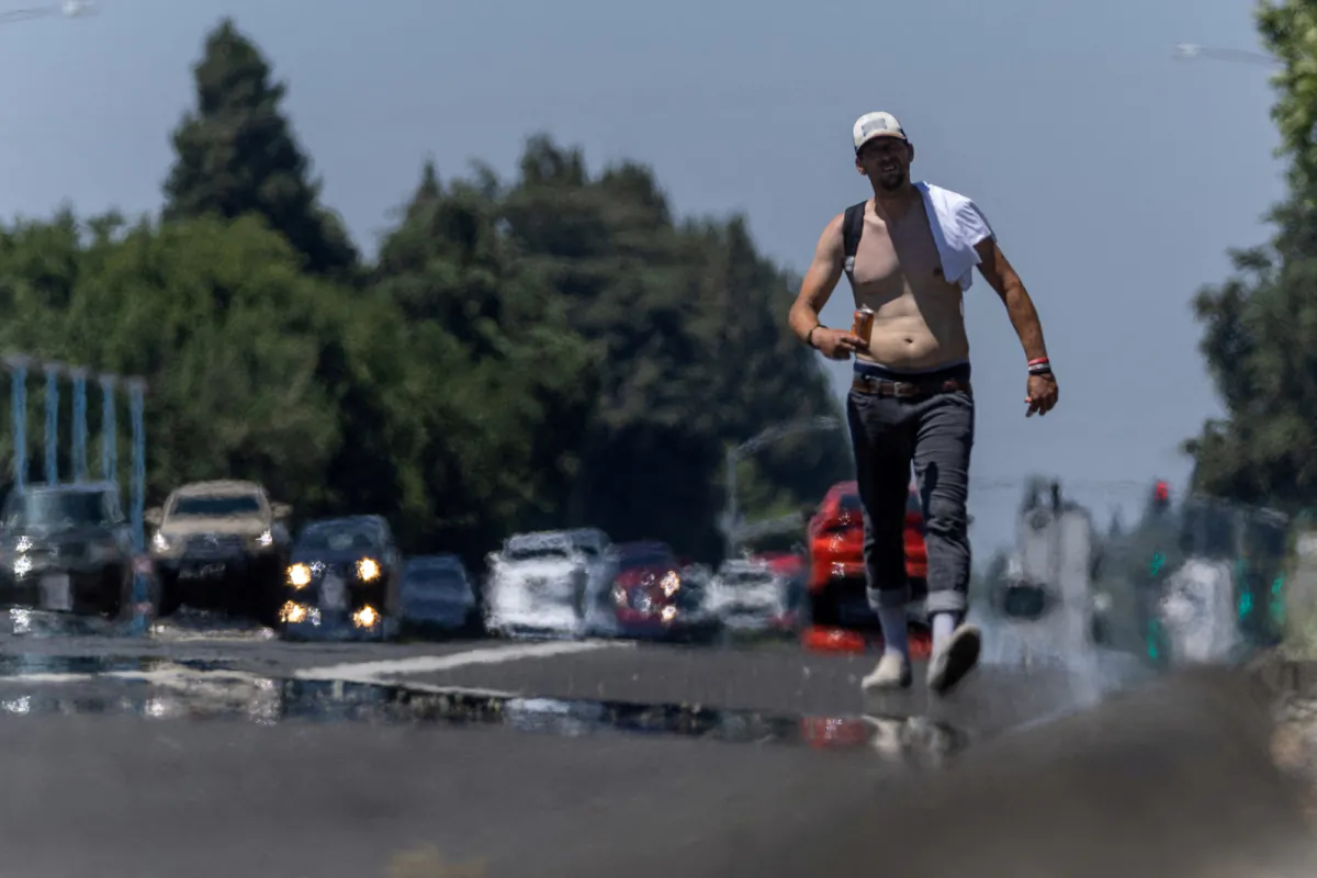 A man walks along a street as temperatures rise above 100 degrees Fahrenheit, in Yuba City, Calif., on June 30, 2023. (Carlos Barria/Reuters)