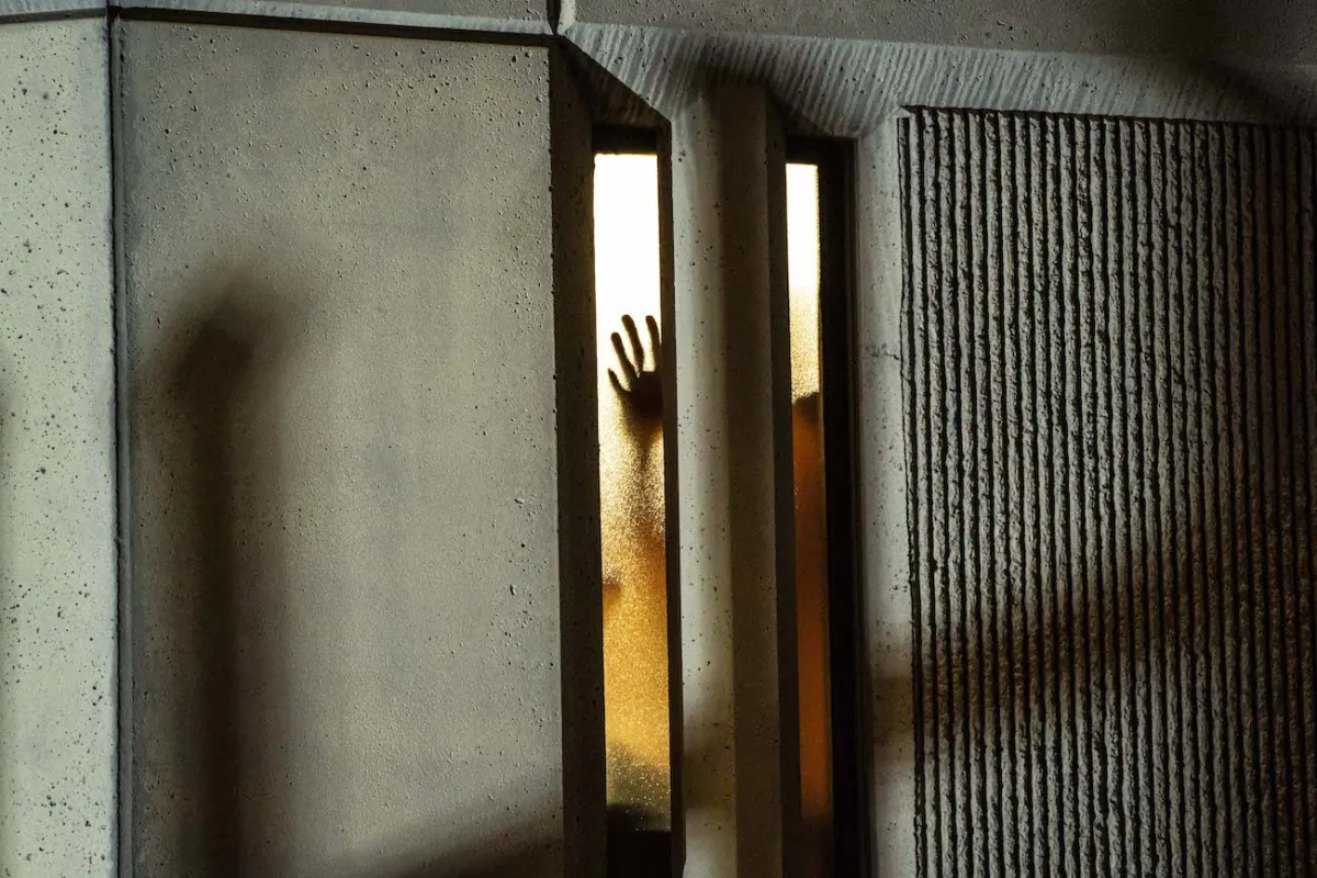 A person places their hand on a window inside a jail in Tacoma, Washington, on Jan. 24, 2021. (David Ryder/Getty Images)