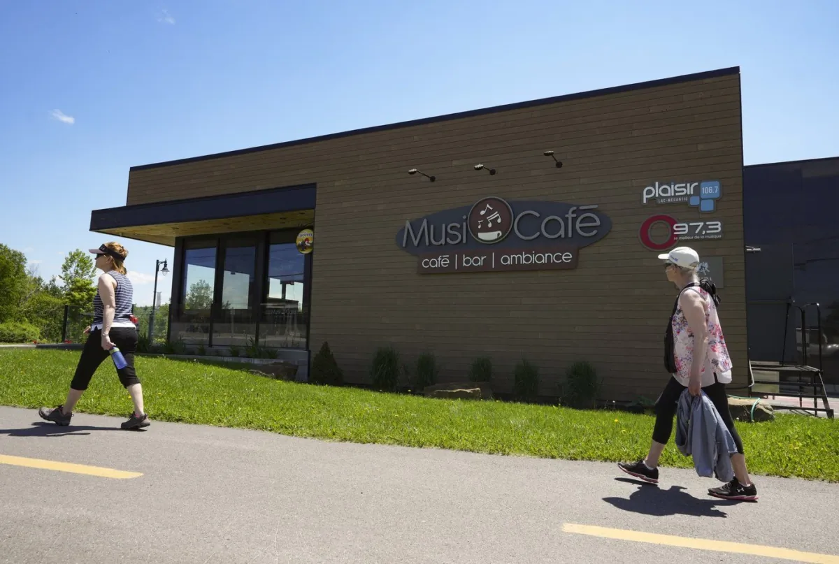 People walk past the new Musi-Cafe in Lac Megantic, Que. on June 22, 2023. (The Canadian Press/Christinne Muschi)

