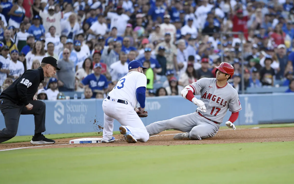 Shohei Ohtani (17) of the Los Angeles Angels slides safely into third base under the tag of third baseman Max Muncy (13) of the Los Angeles Dodgers for a triple with third base umpire Brian Walsh (120) following the action during the third inning at Dodger Stadium in Los Angeles on July 8, 2023. (Kevork Djansezian/Getty Images)