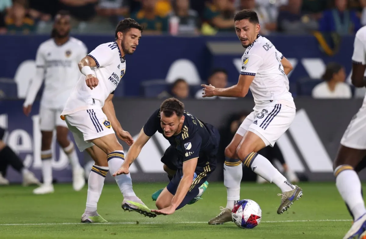 Philadelphia Union midfielder Deniel Gazdag (10) is tackled by Los Angeles Galaxy midfielders Marco Delgado (8) and Gaston Brugman (5) during the first half at Dignity Health Sports Park in Carson, Calif., on Jul 8, 2023. (Jason Parkhurst/USA TODAY Sports via Field Level Media)