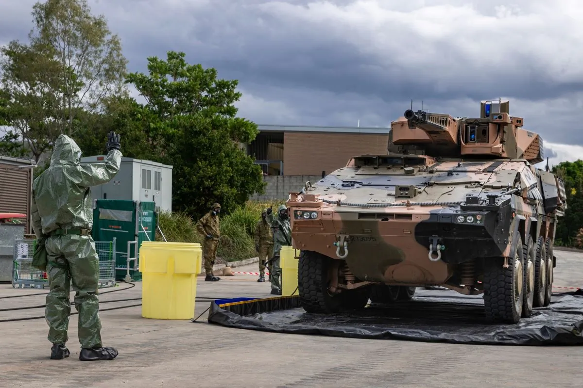 Australian Army sappers from the 2nd Combat Engineer Regiment guide an Boxer Combat Reconnaissance Vehicle through the decontamination bay during a chemical, biological, radiological and nuclear defence training serial at Gallipoli Barracks, Brisbane, May 11, 2023.  (CPL Nicole Dorrett, Australian Defence Forces).