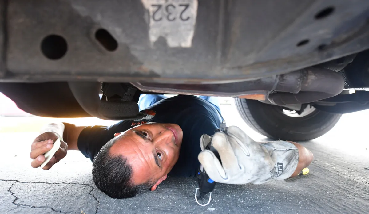 Deputy Jaime Moran from the Los Angeles Sheriff's Department engraves the catalytic converter of a vehicle with a traceable number in City of Industry, California, on July 14, 2021. (Frederic J. Brown/AFP via Getty Images)