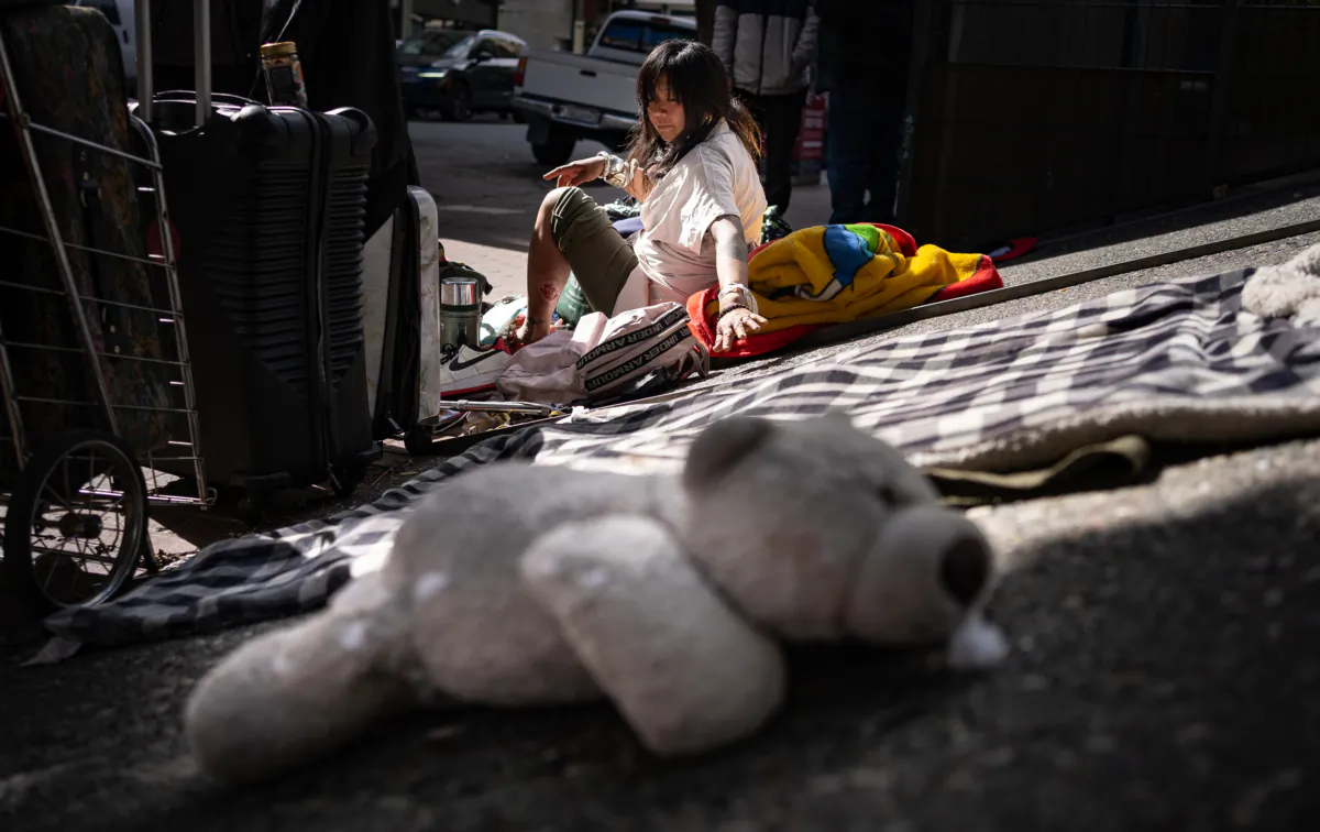 A homeless woman reaches for her teddy bear in San Francisco, on Feb. 22, 2023. (John Fredricks/The Epoch Times)