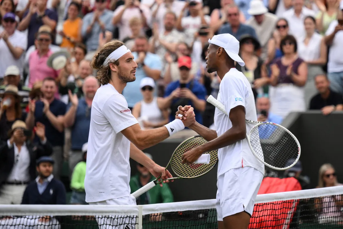 US player Christopher Eubanks (R) shakes hands after winning against Greece's Stefanos Tsitsipas during their men's singles tennis match on the eighth day of the 2023 Wimbledon Championships at The All England Tennis Club in Wimbledon, southwest London, on July 10, 2023. (Daniel Leal/AFP via Getty Images)