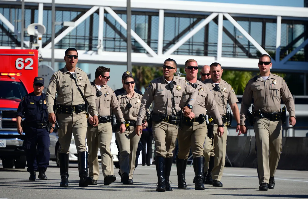 A group of California Highway Patrol officers cross police tape keeping the public from advancing beyond Terminal 1 at Los Angeles International Airport as access roads were closed with flights delayed and canceled on Nov. 1, 2013. (Frederic J. Brown/AFP via Getty Images)