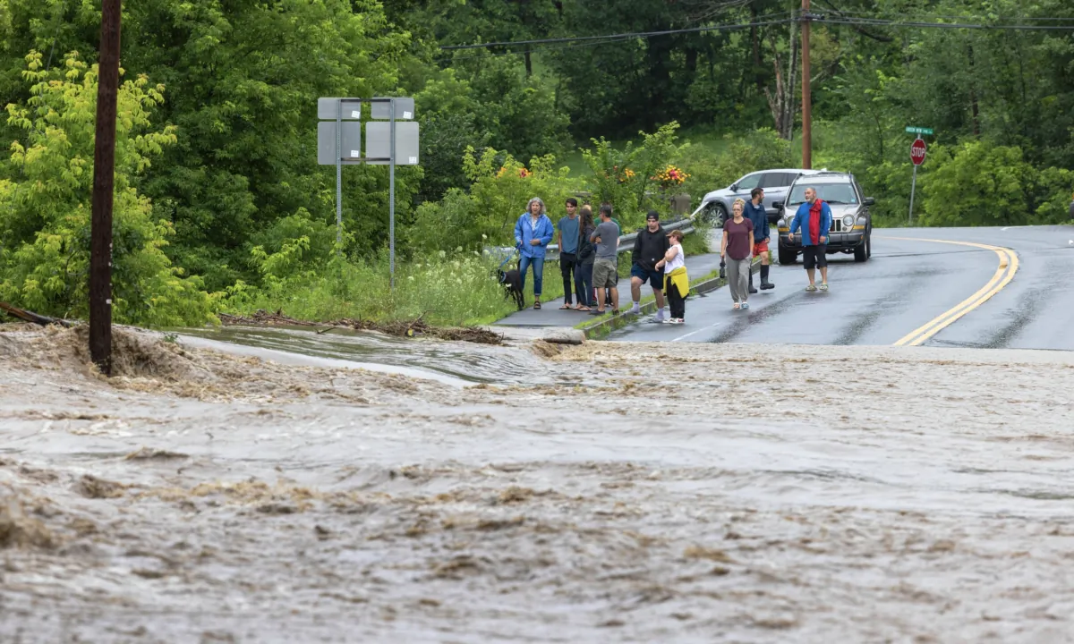 Onlookers check out a flooded road in Chester, Vermont, on July 10, 2023. (Scott Eisen/Getty Images)