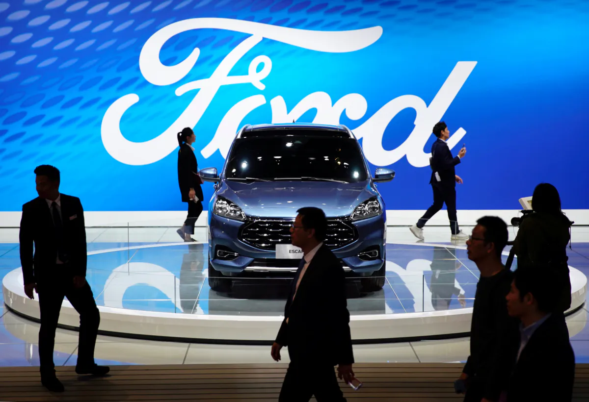 People walk by a Ford Escape SUV displayed during the media day for the Shanghai auto show in Shanghai on April 16, 2019. (Aly Song/Reuters)